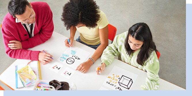 Teacher and two students using Post-it Easy Erase Permanent Marker Whiteboard Sheets to work through math equations together in a classroom setting, viewed from above.
