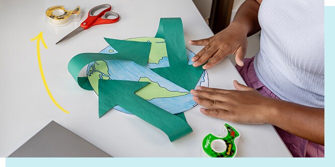 A person making crafts with scotch brand tape.
