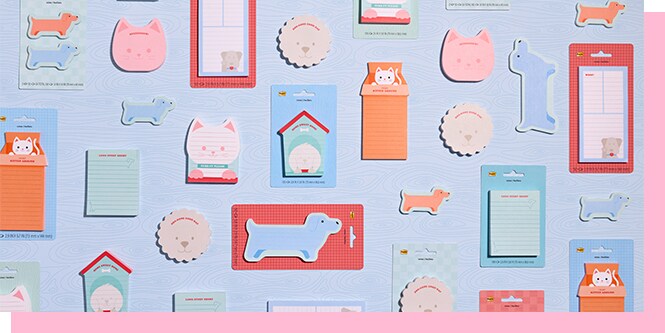 Post-it cat and dog shaped sticky notes and notepads flatlay featuring cute animal designs including cat and puppy shapes on light blue background.
