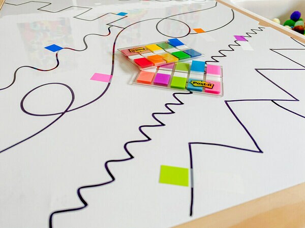 Des Languettes adhésives Post-it® placées sur différentes parties des lignes sur la Surface Flex Write Post-it®.