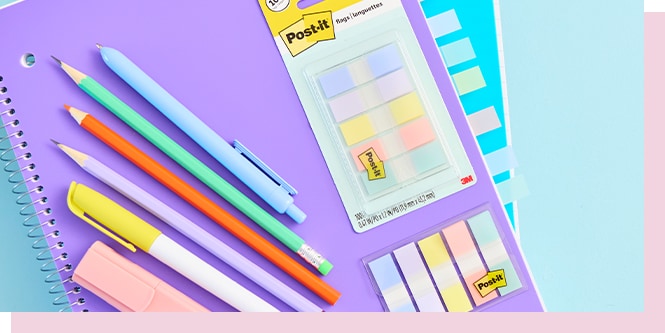 Colorful stationery including notebooks, pens, pencils, and Post-it notes arranged on a pastel background.
